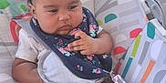 Nadaijah joined the competition — help win amazing prizes! baby, baby_seat, bib, child, chubby, clothing, colorful, comfort, cute, expression, face, hair, hand, indoor, infant, legs, patterned, person, seated, straps