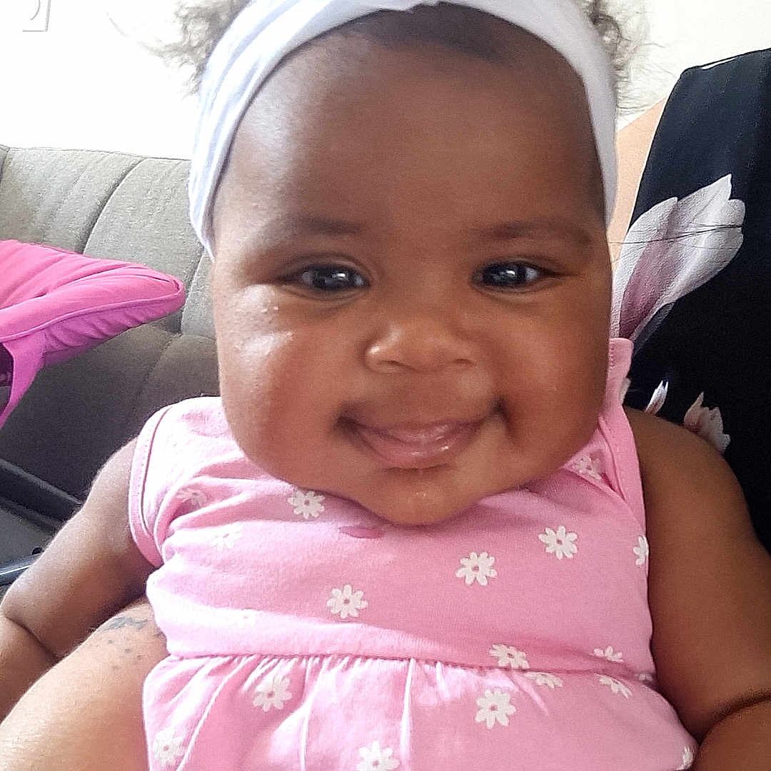 Mëncya participe au concours pour gagner de l'argent avec cette photo : arm, baby, child, closeup, couch, cute, daisies, face, fashion, flower, happy, headband, indoor, infant, person, pink_dress, portrait, sitting, skin, smiling