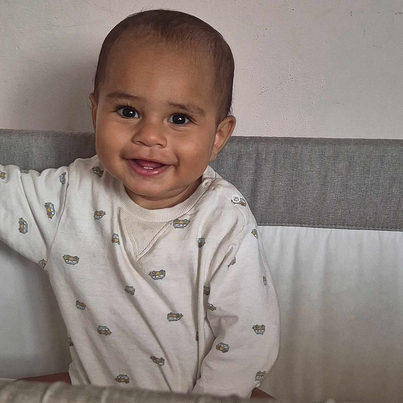 Eden a rejoint le concours — aidez-le/la à gagner de superbes lots ! baby, child, clothing, crib, cute, expression, eyes, face, happy, head, indoor, infant, mouth, onesie, person, portrait, sitting, skin, smiling, young_child