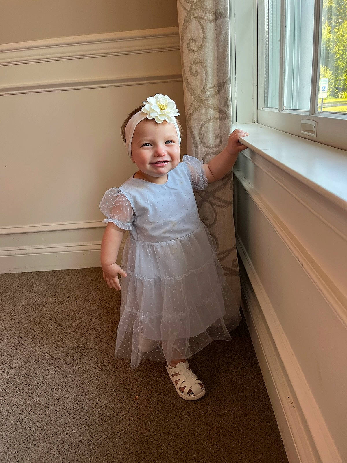 Oaklee is registered to the contest to win money with this photo: baby, baby_toddler_clothing, bridal_accessory, bridal_clothing, child, dress, embellishment, event, flooring, foot, happy, hardwood, headpiece, headwear, human_body, human_leg, joy, person, room, smile