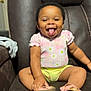 toddler, child, smile, happy, sitting, pink_clothing, yellow_clothing, sandals, leather_chair, indoor, person, cute, baby, footwear, furniture, home, tongue_out, shorts, top, joyful