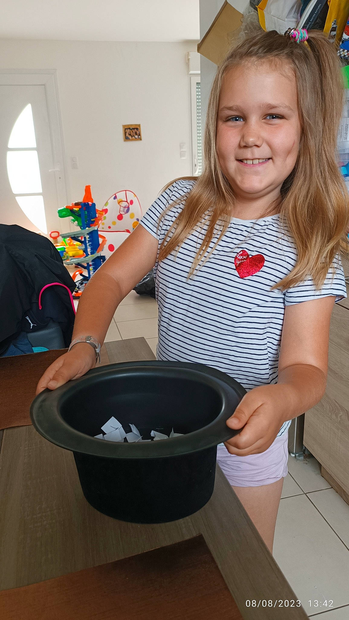 Nina participe au concours pour gagner de l'argent avec cette photo : arm, automotive_tire, automotive_wheel_system, baking, bucket, child, circle, cooking, curtain, event, happy, homemaker, joy, pattern, person, shorts, smile, t_shirt, window