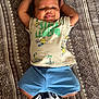 baby, child, smiling, lying_down, tshirt, shorts, socks, blanket, pattern, happy, cute, indoors, person, face, head, arms, legs, footwear, infant, casual_clothing