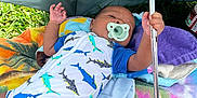 Adonis joined the competition — help win amazing prizes! baby, infant, pacifier, umbrella, blanket, grass, outdoor, child, clothing, hand, lying_down, colorful, shade, relaxation, summer, cute, comfort, toddler, portrait, resting