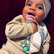 Skylah is registered to the contest to win money with this photo: baby, pacifier, headband, bow, clothing, beige, hand, face, child, cute, infant, portrait, indoors, toddler, expression, soft, fabric, warm, cozy, background