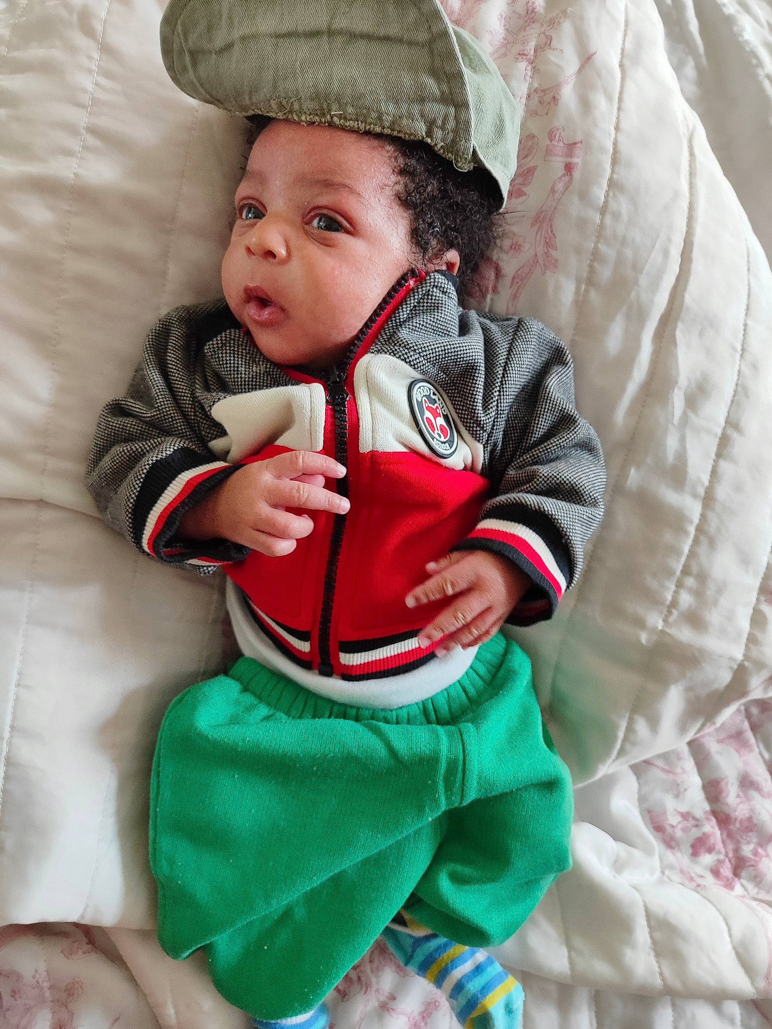 James-dylan participe au concours pour gagner de l'argent avec cette photo : baby, baby_toddler_clothing, cap, child, comfort, costume_hat, eye, face, green, happy, head, headgear, headwear, human_body, linens, person, sitting, skin, sleeve, smile