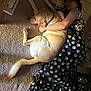 animal, blanket, carpet, casual_clothing, companion, cozy, dog, floor, hugging, human, indoor, labrador, paw_prints, person, pet, relaxation, resting, sleeping, snuggling, warm_light