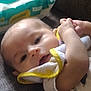 baby, infant, cloth, yellow_trim, face, hand, wipes, package, fabric, lying_down, soft, skin, person, closeup, blurred, indoors, baby_wipes, comfort, resting, newborn