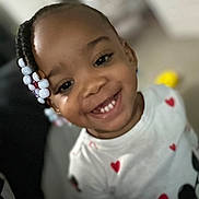 Amiyah is registered to the contest to win money with this photo: child, toddler, smiling, braided_hair, beads, white_shirt, red_hearts, minnie_mouse, indoor, portrait, happy, cute, clothing, face, person, black_hair, young_child, closeup, joyful, fashion