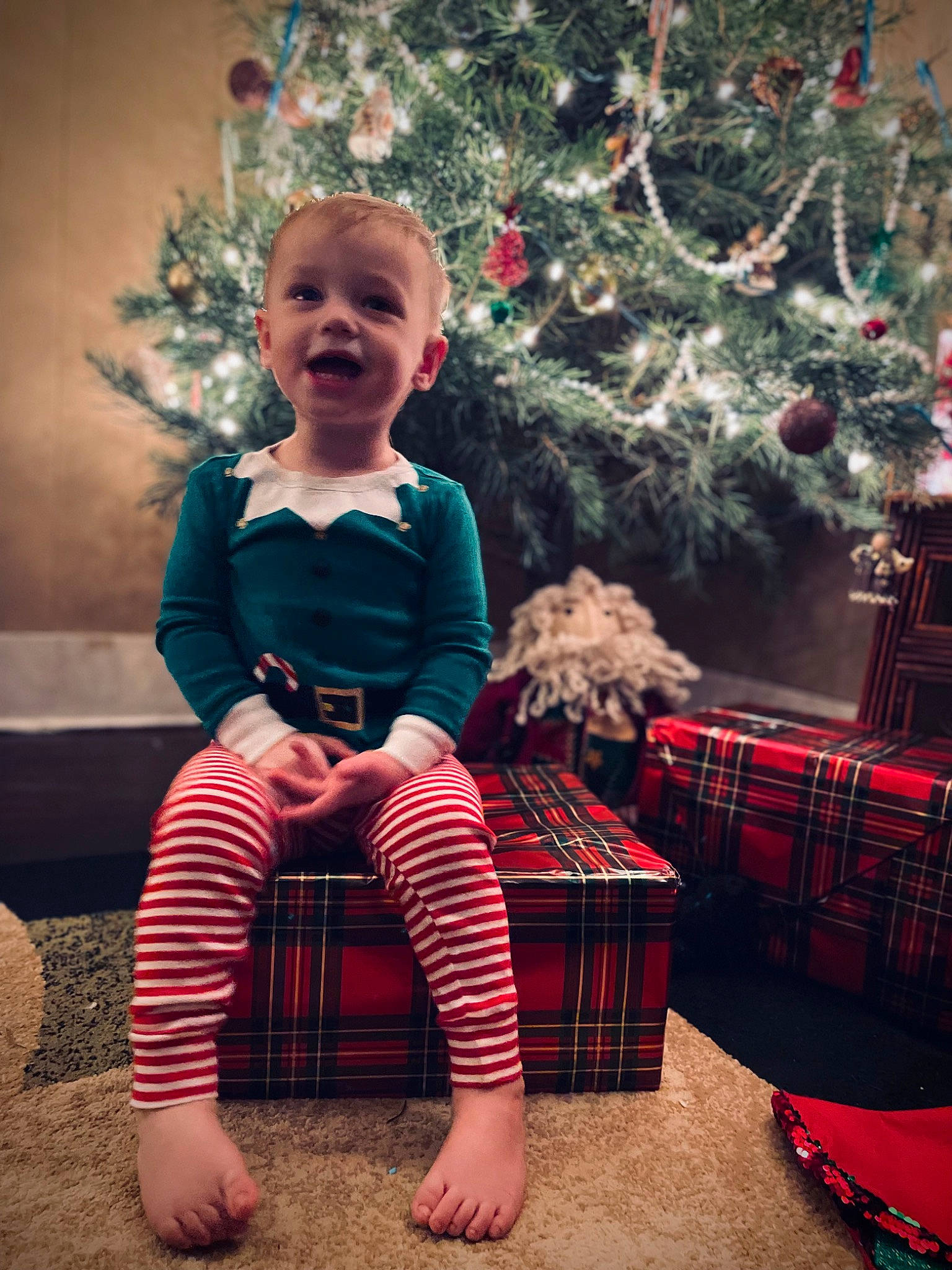 Tobias joined the competition — help win amazing prizes! baby_toddler_clothing, christmas, christmas_decoration, christmas_ornament, christmas_tree, flash_photography, happy, light, pattern, person, photograph, pink, plaid, plant, red, smile, standing, tartan, toddler, tree