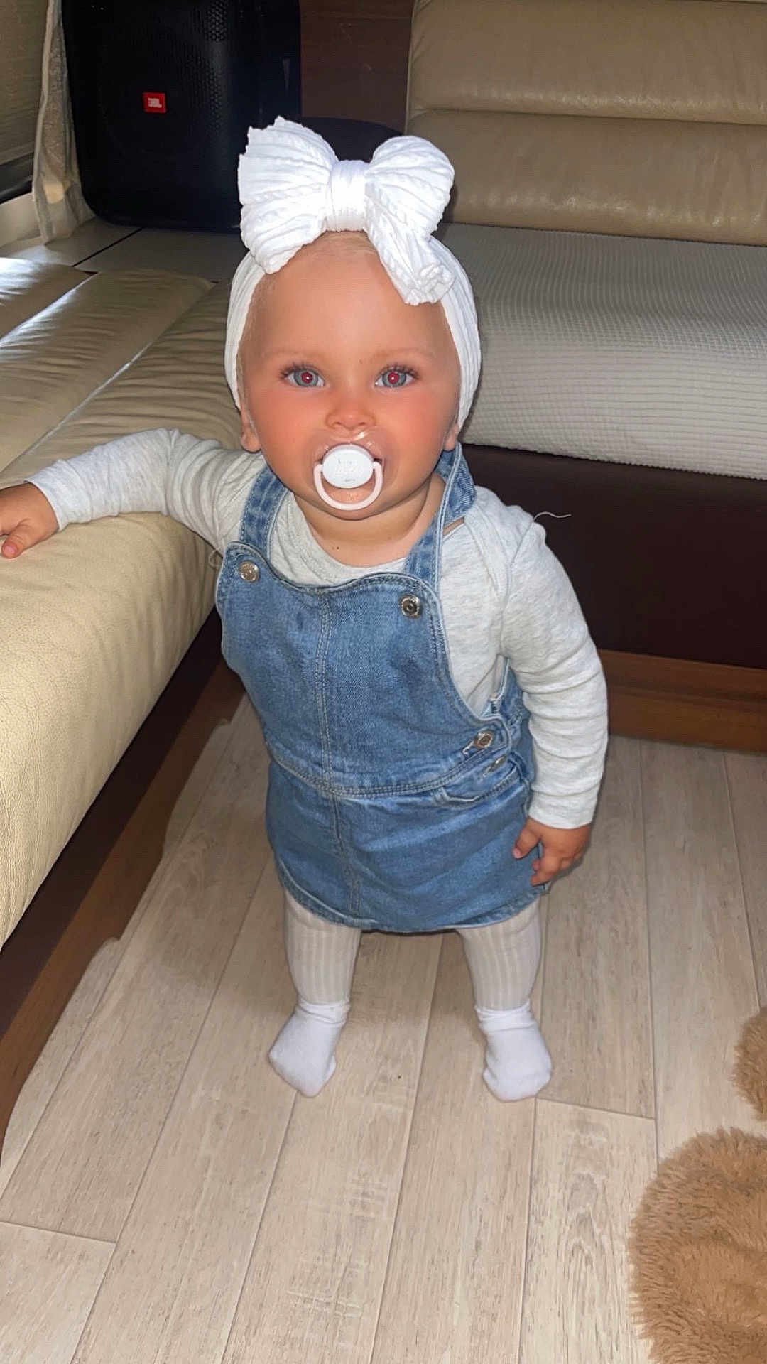 Saona a rejoint le concours — aidez-le/la à gagner de superbes lots ! toddler, child, pacifier, headband, bow, denim, overall, dress, socks, floor, wooden_floor, couch, living_room, indoor, furniture, person, cute, baby, standing, clothing