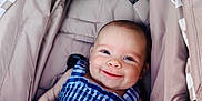 Lillie is registered to the contest to win money with this photo: baby, smiling, stroller, blue_clothing, checkered_pattern, infant, child, happy, cute, drool, outdoor, seat, fabric, canopy, person, young_child, portrait, resting, casual, comfort