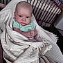 baby, blanket, infant, wrapped, crib, wooden_crib, blue_eyes, clothing, person, indoor, soft_texture, fringe, bedroom, toy, serious_expression, human, newborn, portrait, child, resting