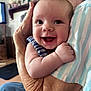 Lillie is registered to the contest to win money with this photo: baby, infant, smile, happy, face, person, arm, hand, elderly_person, wrinkles, striped_clothing, indoor, home, furniture, background_blur, closeup, skin, holding, love, generations
