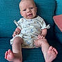 Lillie joined the competition — help win amazing prizes! baby, infant, child, couch, furniture, blue, white_clothing, sitting, feet, smiling, face, head, indoors, cute, young_child, person, portrait, comfort, fabric, home