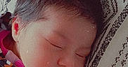 Delilah joined the competition — help win amazing prizes! baby, sleeping, infant, portrait, face, closed_eyes, pink_bow, hair, patterned_blanket, blanket, bed, lying_down, peaceful, cute, child, newborn, clothing, patterned_clothes, indoors, close_up