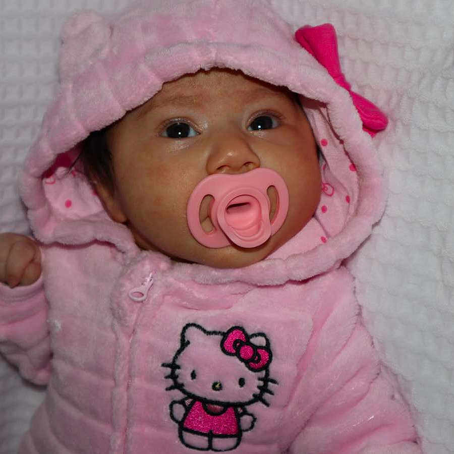 Delilah is registered to the contest to win money with this photo: baby, infant, child, pink_outfit, pink_hat, pacifier, hello_kitty, portrait, close_up, lying_down, blanket, textured_fabric, indoor, cozy, wide_eyes, looking_at_camera, baby_clothing, hood, cute, photography