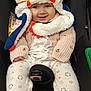 Talia a rejoint le concours — aidez-le/la à gagner de superbes lots ! baby, blue_hat, car_seat, cat_hat, child, clothing, cozy, cute, face, footed_pajamas, happy, indoors, infant, knitted_hat, orange_accents, patterned_clothing, person, seated, smiling, sweater
