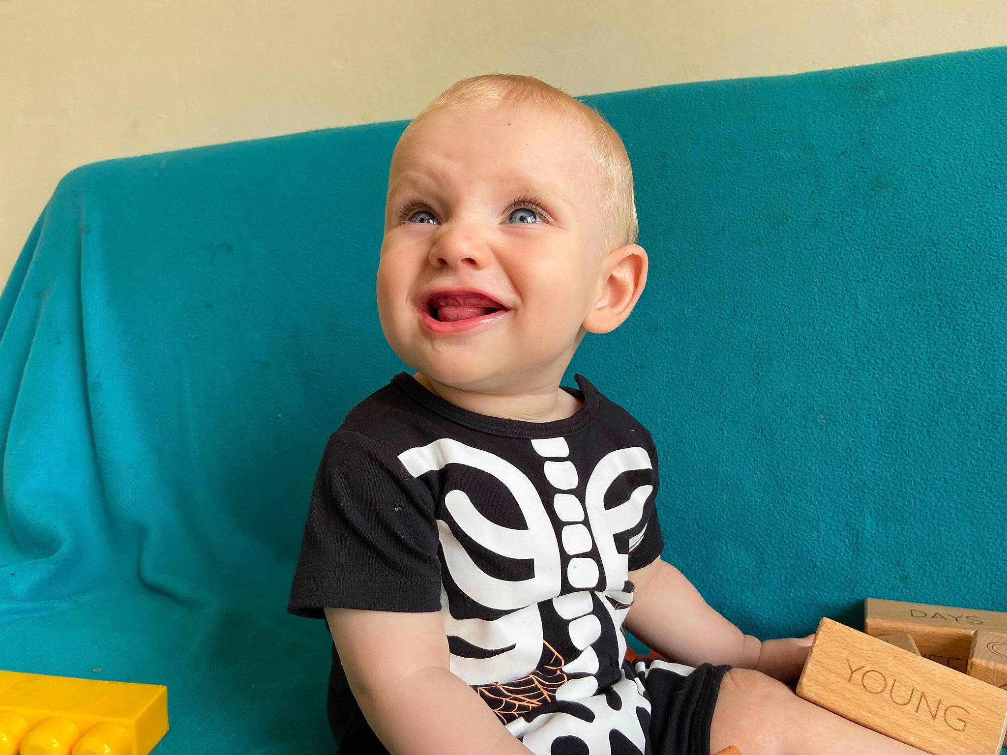 Elijah is registered to the contest to win money with this photo: arm, baby, baby_toddler_clothing, cheek, child, face, facial_expression, head, joy, nose, person, play, sitting, smile, t_shirt, toddler