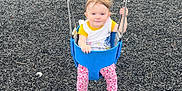 Mckenna is registered to the contest to win money with this photo: child, toddler, swing, playground, smiling, outdoor, fence, tree, grass, chain, clothing, pants, top, footwear, play, seat, baby, recreation, park, daylight