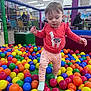 Mckenna joined the competition — help win amazing prizes! toddler, child, ball_pit, colorful_balls, indoor_play_area, netting, coral_shirt, pink_pants, socks, people_in_background, chairs, tables, playground, playing, fun, young_child, cute, activity, indoor, net_fence