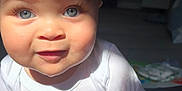 Calais is registered to the contest to win money with this photo: baby, child, blue_eyes, eyelashes, white_shirt, indoor, sunlight, shadow, curious, sitting, infant, cute, face, portrait, closeup, person, smile, skin, head, young_child