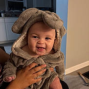 Calais is registered to the contest to win money with this photo: baby, child, smiling, hoodie, plush, indoor, person, hand, cute, happy, face, clothing, infant, warm, soft, cozy, kitchen, portrait, sitting, toddler