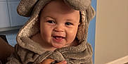 Calais is registered to the contest to win money with this photo: baby, child, clothing, cozy, cute, face, hand, happy, hoodie, indoor, infant, kitchen, person, plush, portrait, sitting, smiling, soft, toddler, warm