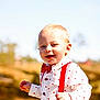 Hailey is registered to the contest to win money with this photo: toddler, child, boy, outdoor, sunny, shirt, red_suspender, bow_tie, smiling, walking, face, blond_hair, nature, daylight, cute, happy, jeans, portrait, casual, background_blur
