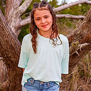 Aubree is registered to the contest to win money with this photo: child, girl, smile, curly_hair, braids, casual_clothing, jeans, tshirt, outdoor, nature, tree, portrait, young, fashion, standing, happy, grass, sunlight, background, dimple