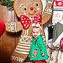 Savanna joined the competition — help win amazing prizes! child, christmas_theme, cute, decorations, fabric, festive, floor, gingerbread_man, green_dress, headband, holiday_decor, holiday_season, indoors, red_polka_dot_pants, smiling, toddler, toy, white_shoes, wooden_door, wreath