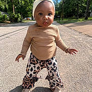 Layani is registered to the contest to win money with this photo: toddler, child, street, outdoor, sunlight, trees, headband, beige_top, leopard_print_pants, shoes, confident, walking, sidewalk, nature, portrait, young_child, fashion, cute, person, daytime