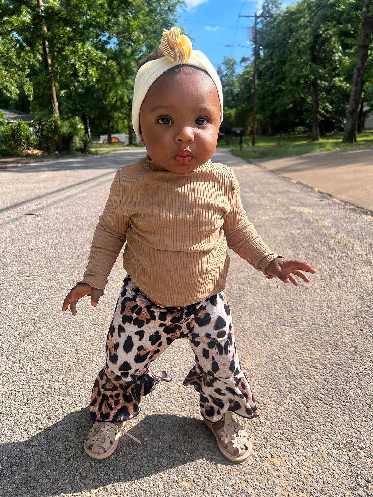Layani is registered to the contest to win money with this photo: toddler, child, street, outdoor, sunlight, trees, headband, beige_top, leopard_print_pants, shoes, confident, walking, sidewalk, nature, portrait, young_child, fashion, cute, person, daytime