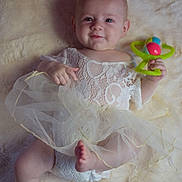 Luna a rejoint le concours — aidez-le/la à gagner de superbes lots ! baby, infant, smile, lace_dress, diaper, rattle, toy, blanket, fur_blanket, lying_down, portrait, barefoot, feet, hand, face, head, eyes, soft_texture, tulle, cute