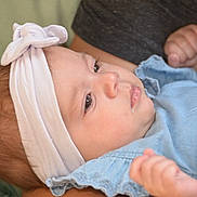 Melody participe au concours pour gagner de l'argent avec cette photo : baby, blue_clothing, bow, calm, candid, child, closeup, drool, face, fingers, hand, headband, indoor, infant, newborn, person, portrait, resting, skin, soft_lighting