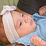 baby, blue_clothing, bow, calm, candid, child, closeup, drool, face, fingers, hand, headband, indoor, infant, newborn, person, portrait, resting, skin, soft_lighting