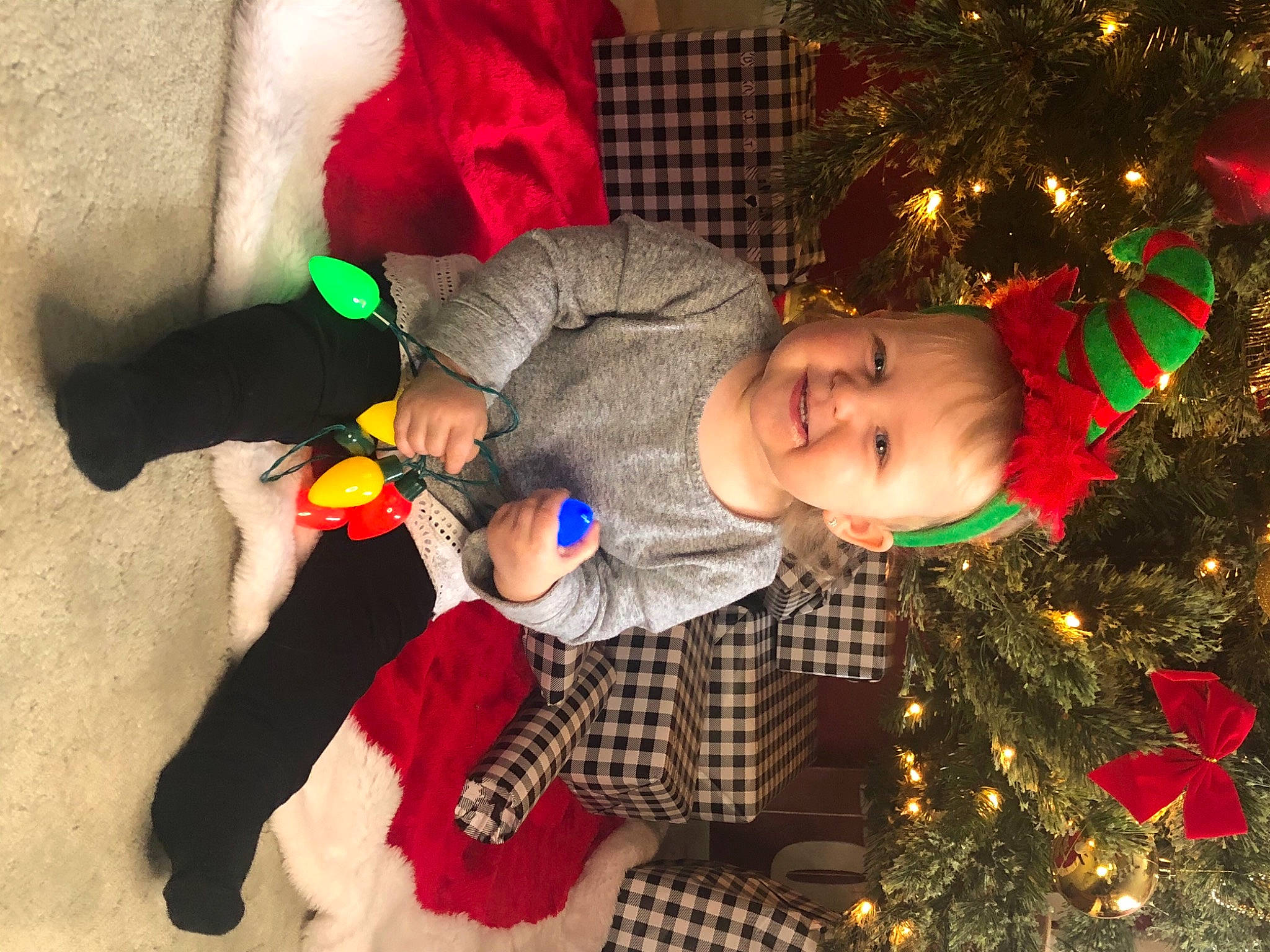 Arden joined the competition — help win amazing prizes! baby_toddler_clothing, christmas, christmas_decoration, christmas_eve, christmas_lights, christmas_ornament, christmas_tree, costume_accessory, event, fictional_character, fur, holiday, holiday_ornament, human, human_body, interior_design, joy, lap, person, plush