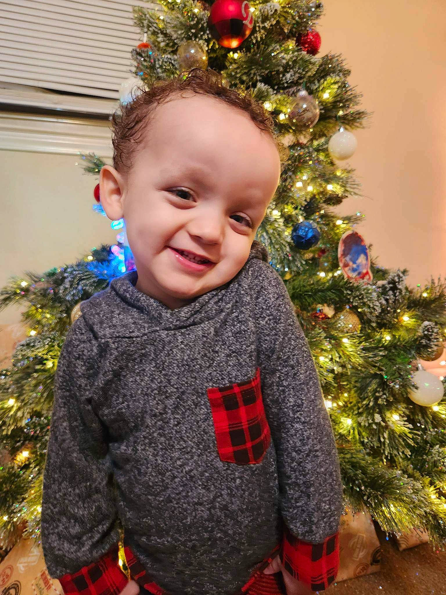 Roman joined the competition — help win amazing prizes! baby_toddler_clothing, christmas, christmas_decoration, christmas_ornament, christmas_tree, event, eye, happy, holiday, holiday_ornament, iris, joy, ornament, outerwear, person, red, sleeve, smile, toddler, tree