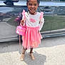 Leah joined the competition — help win amazing prizes! child, girl, smiling, dress, pink, white, braids, beads, purse, sandals, car, sidewalk, shadow, outdoor, sunny, happy, fashion, portrait, standing, person