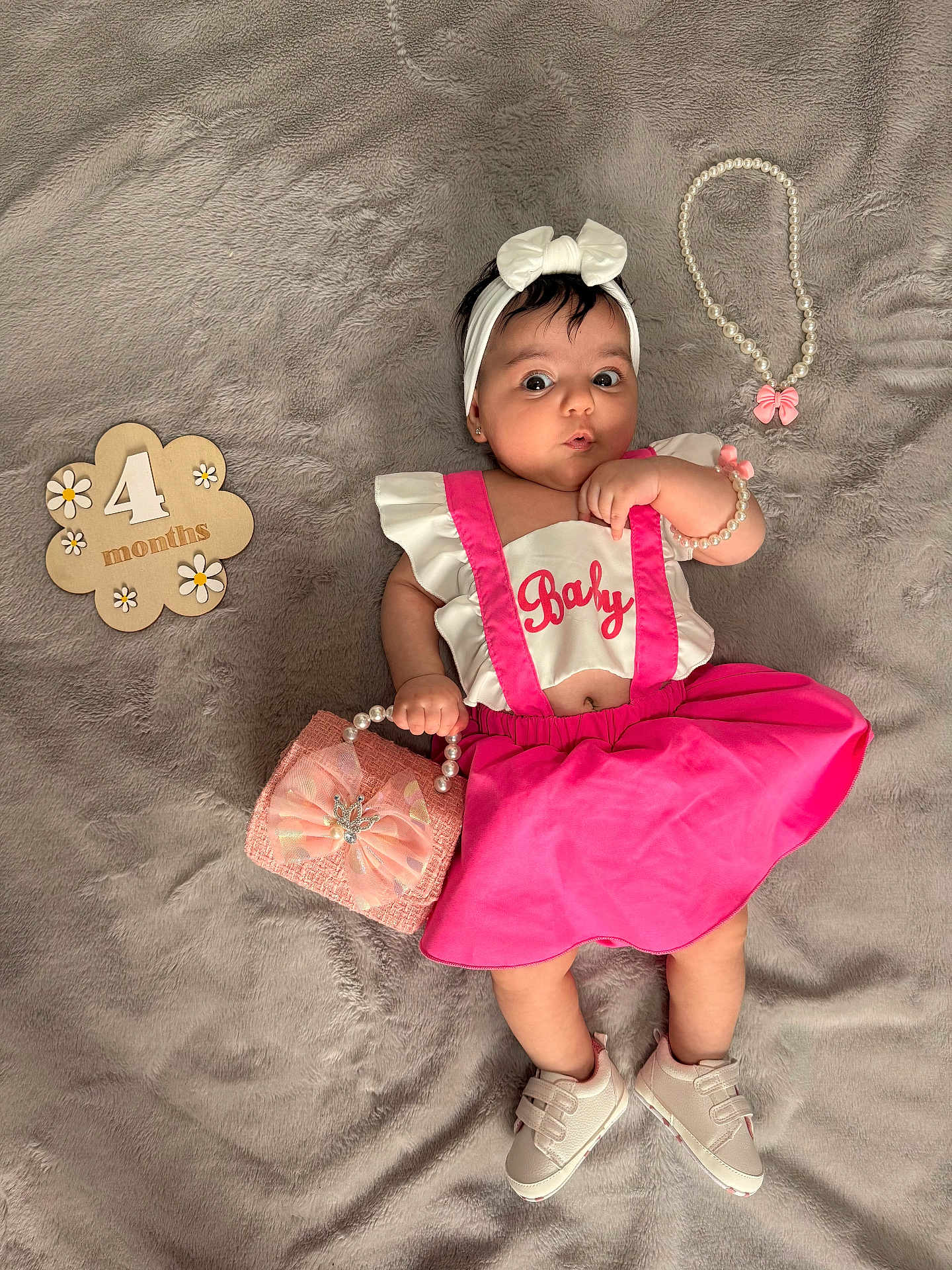 Kumru joined the competition — help win amazing prizes! baby, infant, pink_skirt, white_top, headband, pearl_bracelet, small_purse, pearl_necklace, wooden_sign, 4_months, blanket, shoes, cute, lying_down, portrait, child, adorable, soft_texture, accessories, indoor