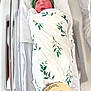 newborn, baby, swaddle, green_cap, hospital_bassinet, peaceful, sleeping, wooden_sign, hello_world, leaf_pattern, infant, blanket, bed, portrait, cute, child, resting, hospital, soft_lighting, fresh