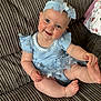 baby, child, smiling, blue_dress, headband, couch, indoor, happy, cute, infant, portrait, sitting, skin, face, hand, foot, furniture, clothing, headwear, person