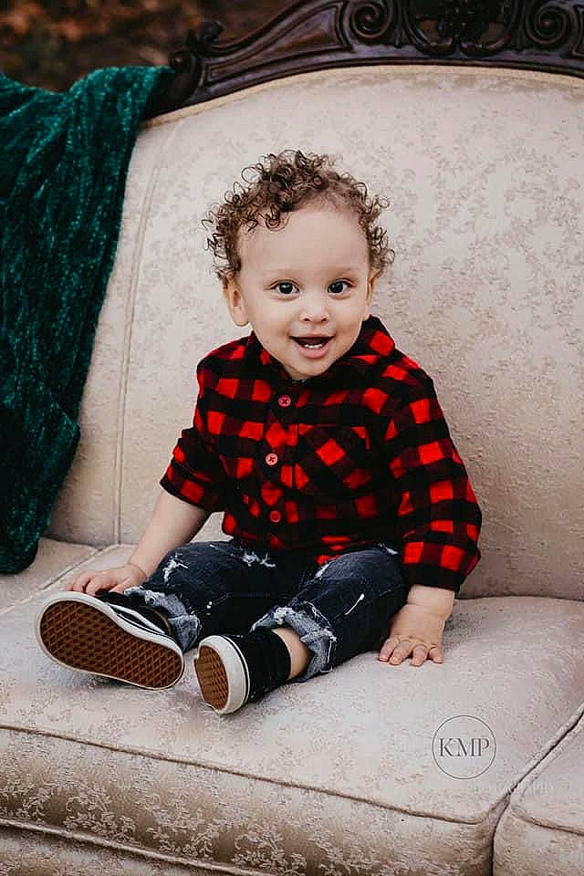 Cainan is registered to the contest to win money with this photo: baby_toddler_clothing, black, child, couch, dress, eye, face, flash_photography, flooring, hairstyle, happy, outerwear, pattern, person, sleeve, smile, standing, style, textile, toddler