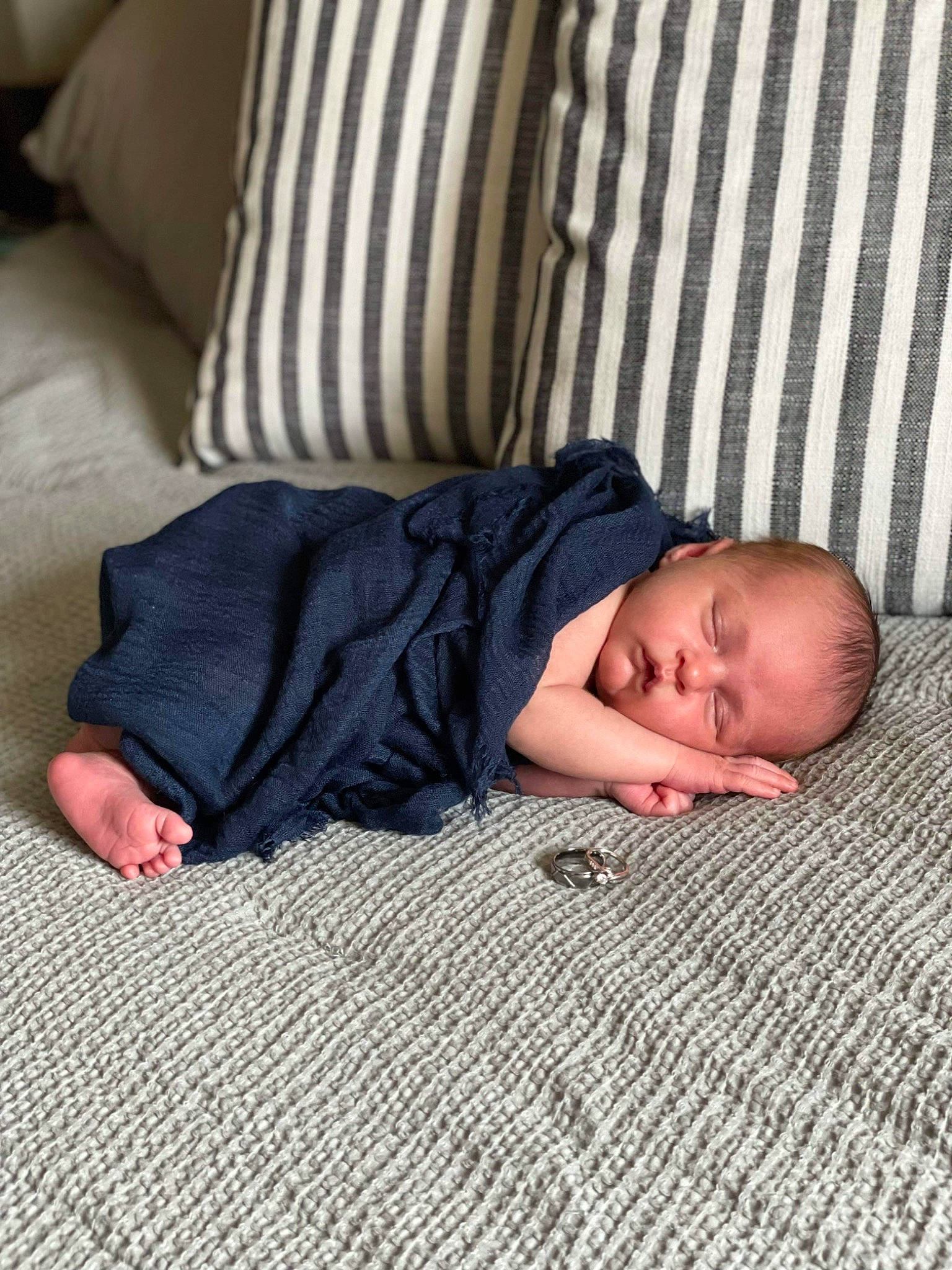 Dominic is registered to the contest to win money with this photo: baby, baby_toddler_clothing, bedding, bedtime, child, comfort, couch, floor, flooring, foot, hardwood, human_leg, linens, nap, pattern, person, room, sitting, sleep, toddler