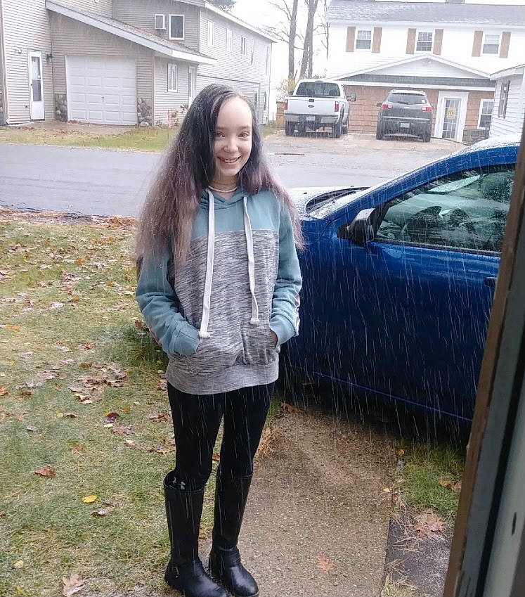 Jessi is registered to the contest to win money with this photo: asphalt, car, denim, footwear, grass, hair, human_body, jacket, jeans, joy, knee, person, sleeve, smile, street_fashion, tire, tree, vehicle, vehicle_door, waist