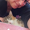 woman, cat, kitten, portrait, selfie, cuddling, glasses, eyeglasses, blonde_hair, tabby, white_fur, green_eyes, indoors, blanket, pink, close_up, pet, companion, relaxed, adorable