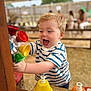 George joined the competition — help win amazing prizes! child, toddler, boy, playing, toy, colorful, bells, wooden, striped_shirt, outdoor, canopy, happy, smiling, blonde_hair, person, fun, daylight, background_people, excited, activity