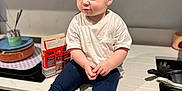 George joined the competition — help win amazing prizes! toddler, child, kitchen, counter, white_tshirt, navy_leggings, sneakers, sitting, face, hair, modern_kitchen, curious, food_on_mouth, domestic, indoor, person, young_child, footwear, cute, casual_clothing