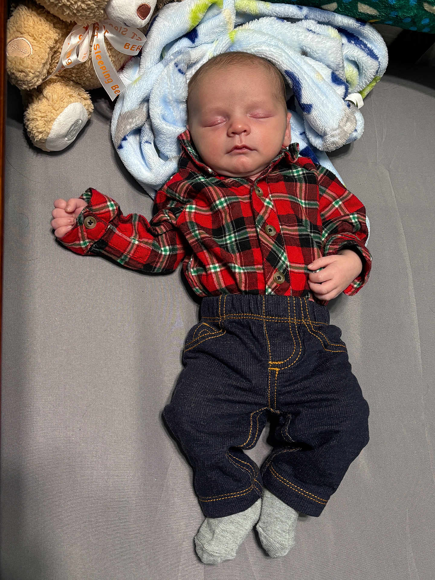 Colter joined the competition — help win amazing prizes! baby, infant, newborn, sleeping, plaid_shirt, flannel_shirt, jeans, socks, blanket, teddy_bear, soft_toy, crib, bedding, lying_down, peaceful, portrait, face, hands, nursery, cozy