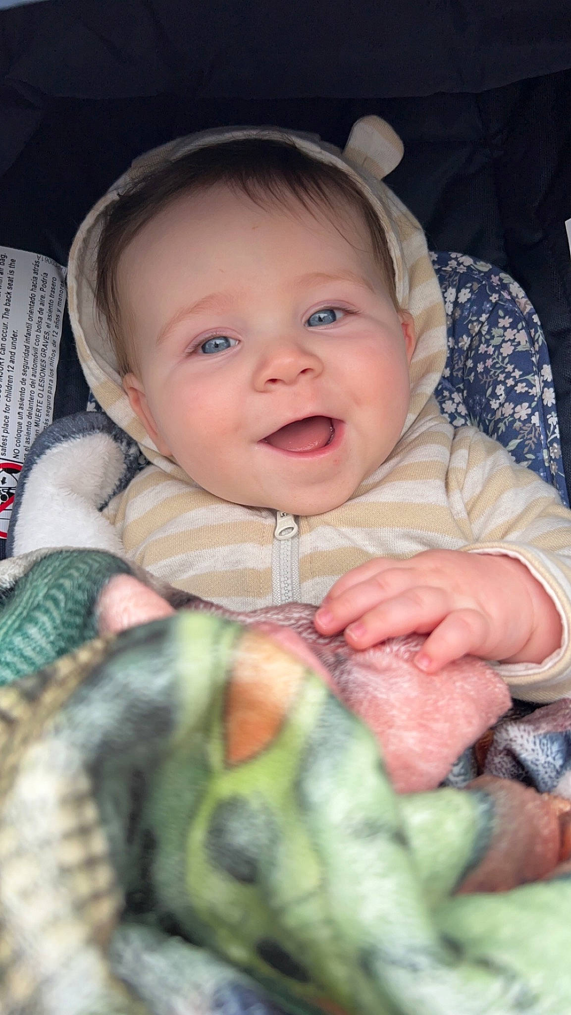 Logan is registered to the contest to win money with this photo: baby, baby_products, baby_toddler_clothing, cheek, child, comfort, eye, finger, gesture, happy, iris, linens, mouth, nose, pattern, person, sitting, skin, sleeve, smile